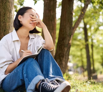 Sad girl crying while writing her diary sitting alone tree park with her notebook sobbin 1258 122939 360x320